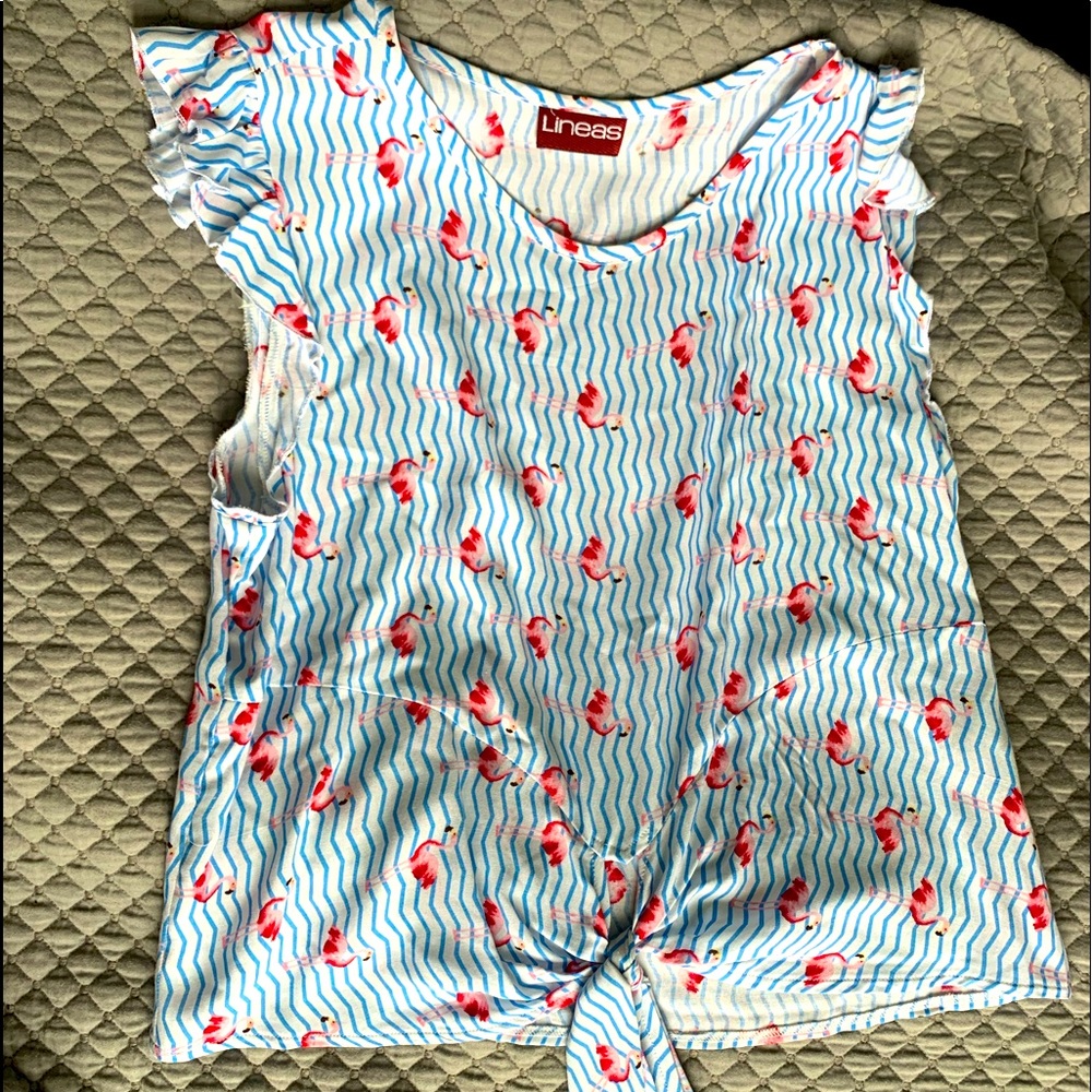 The shirt has a cross tie. ruffles around sleeve